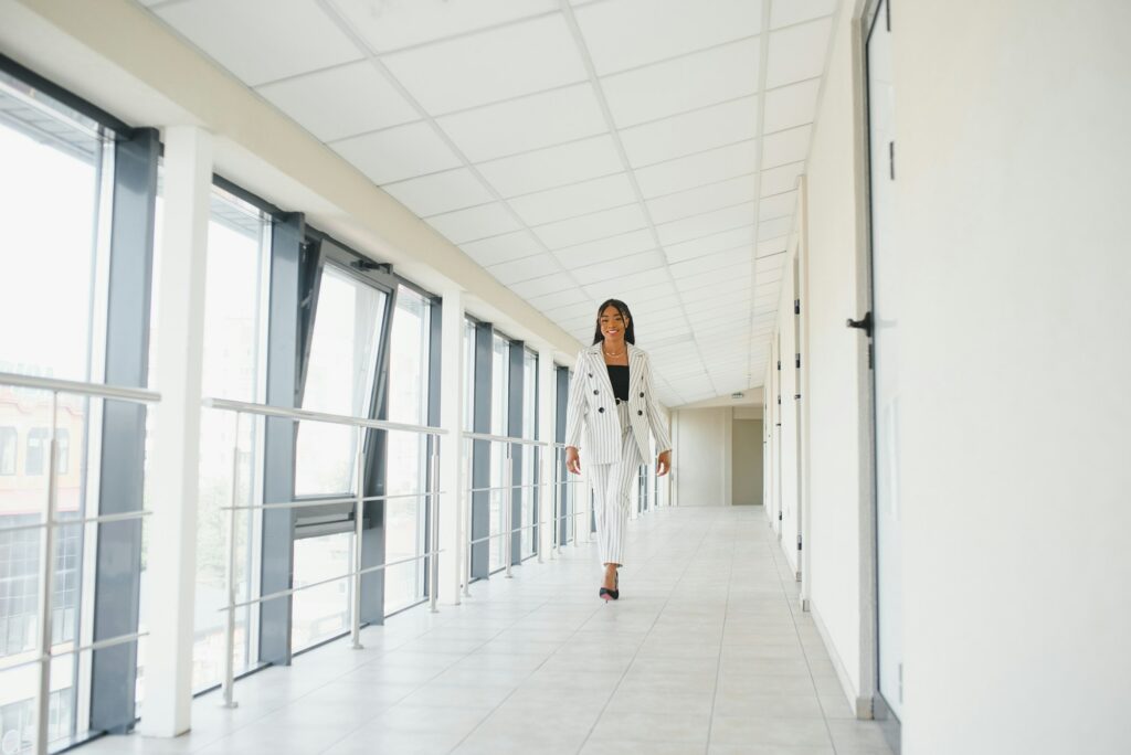 Young Businesswoman Standing In Corridor Of Modern Office Building